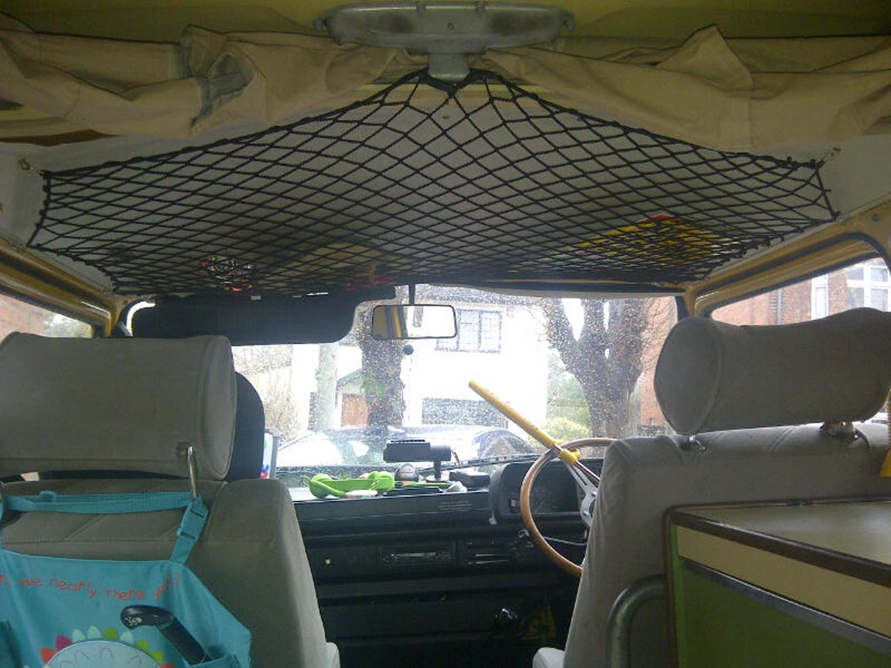 Black elastic net with bungee cord to create storage space on the roof of a camper van.