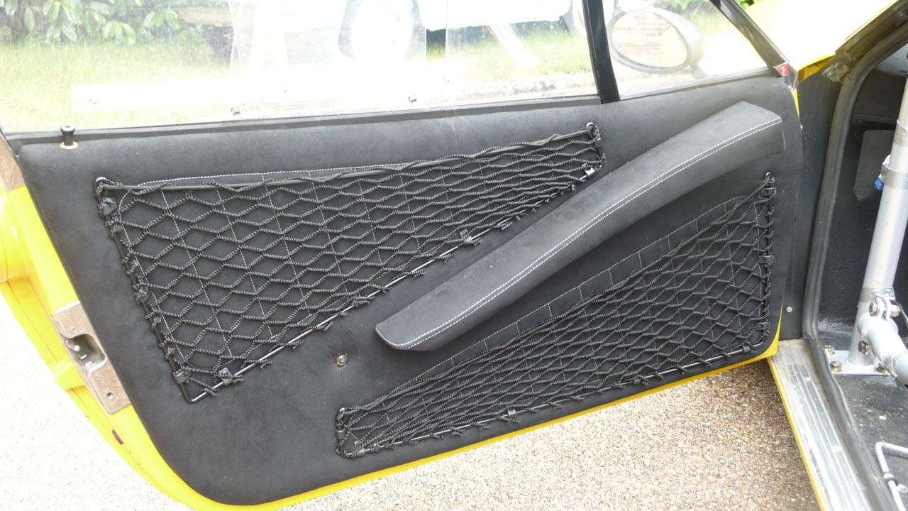 Bespoke frame elastic nets shaped to provide custom storage space inside a car door