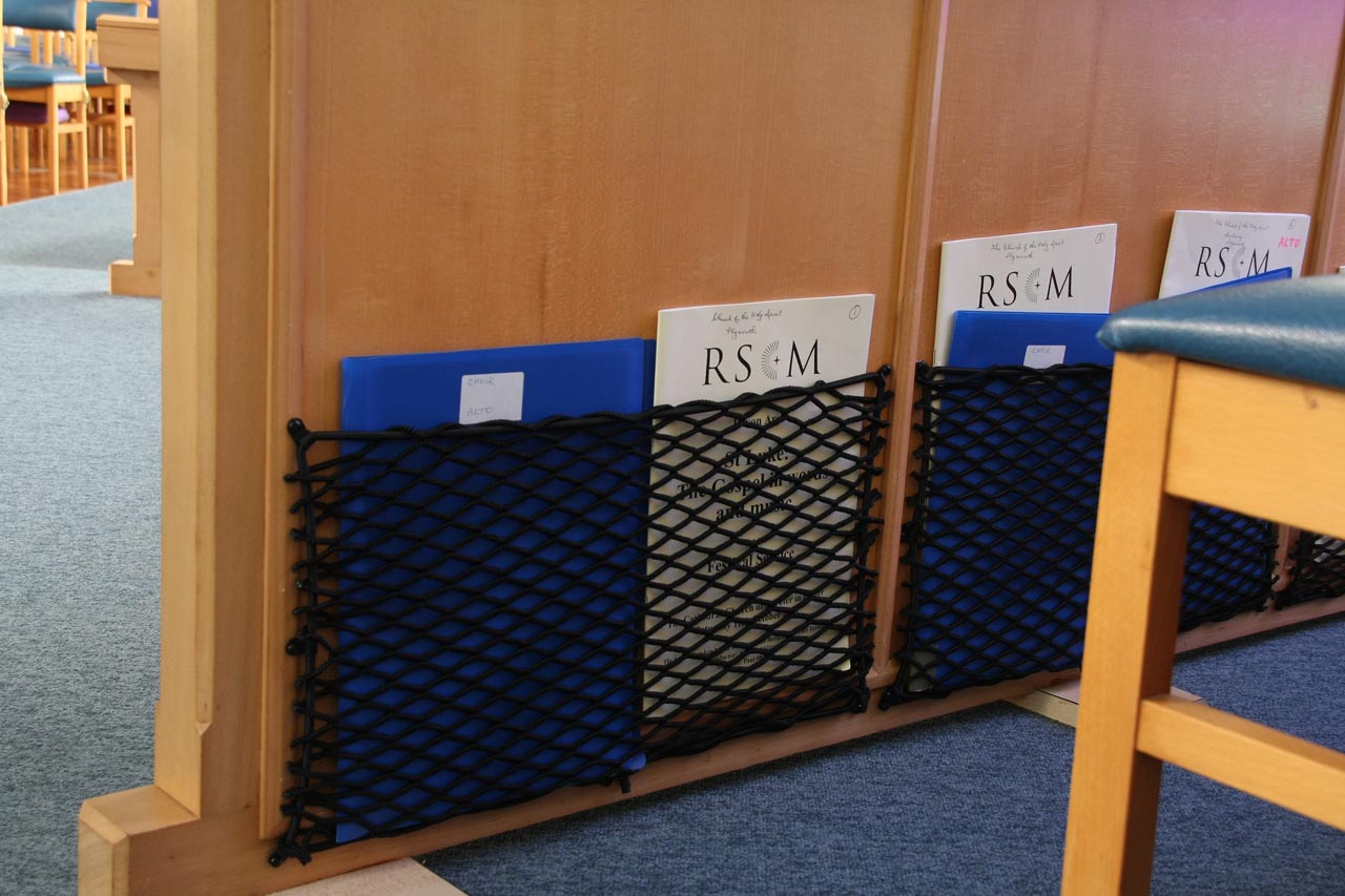 Close-up of bespoke elastic nets for organisation of books and music in a Church