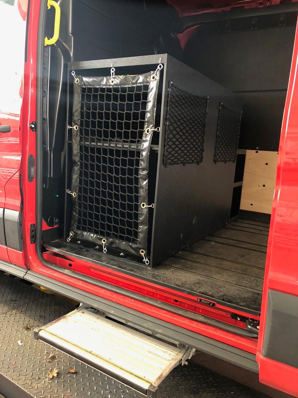 Bespoke cargo net in front of shelving and frame elastic nets in a fire training van (customer photo).