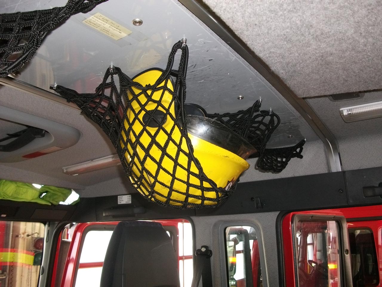 Bespoke elastic netting for helmet storage in a fire engine