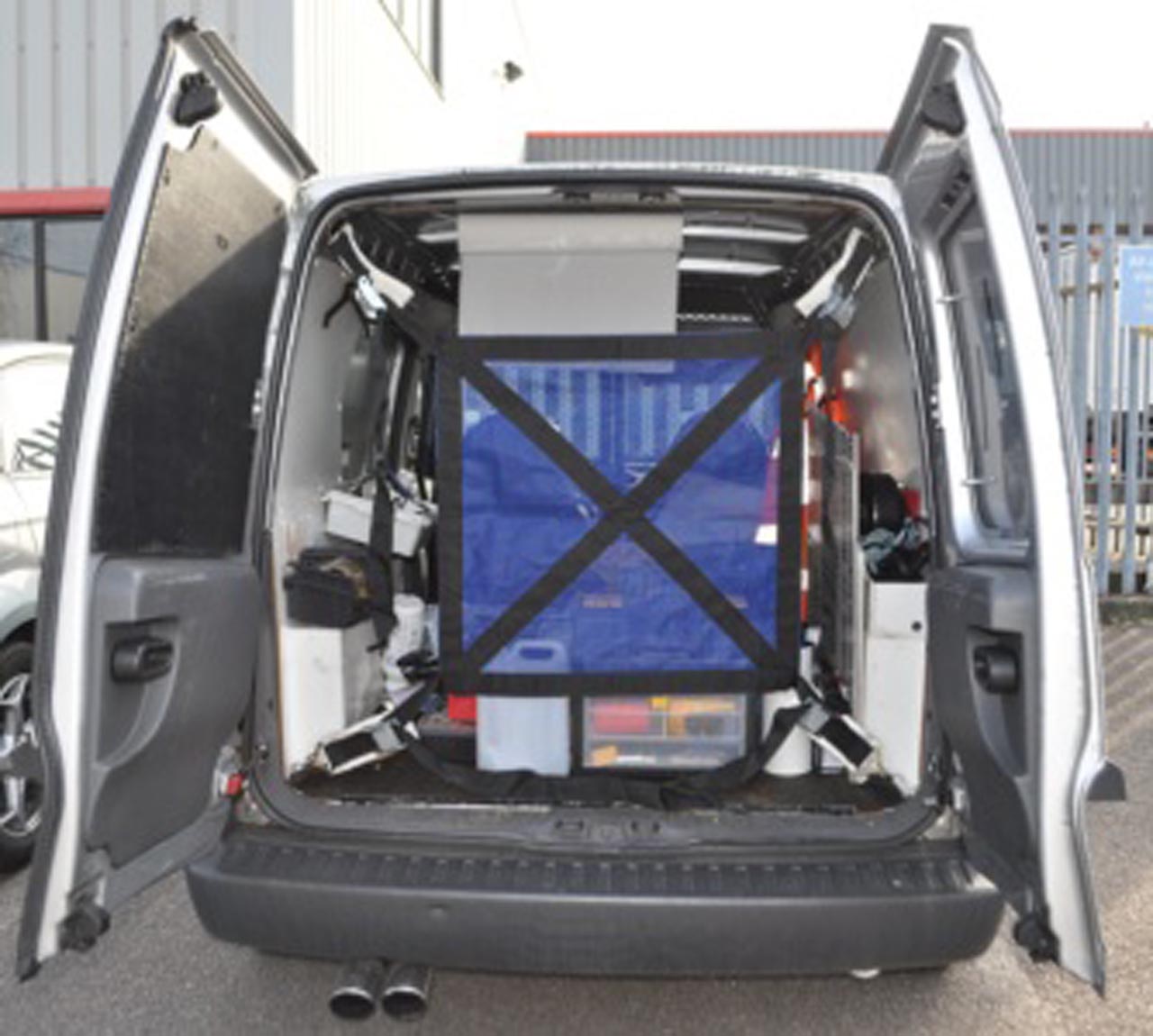 Load restraint net with ratchets fitted in the back of a vehicle.