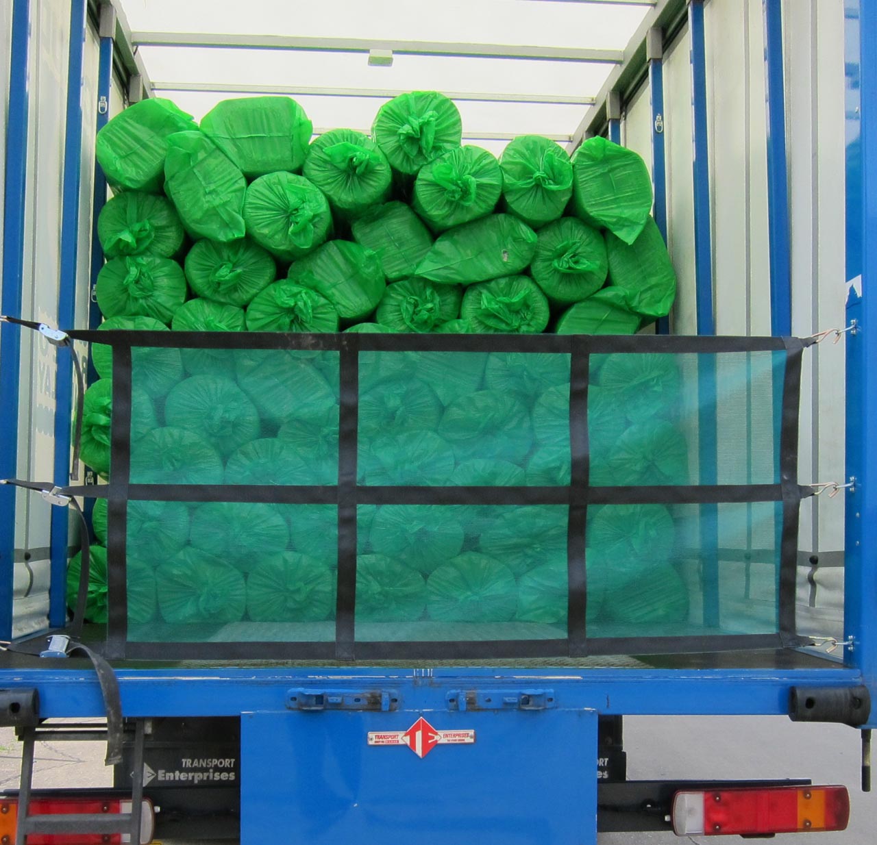 Load restraint mesh net with webbing and fittings on the back of a truck
