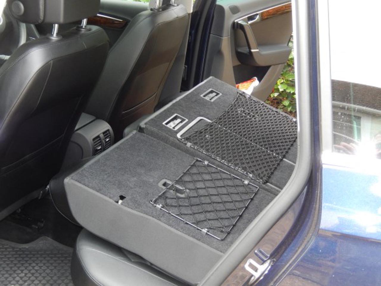 Custom-made frame elastic nets to create storage space behind the rear seats in a VW Passat