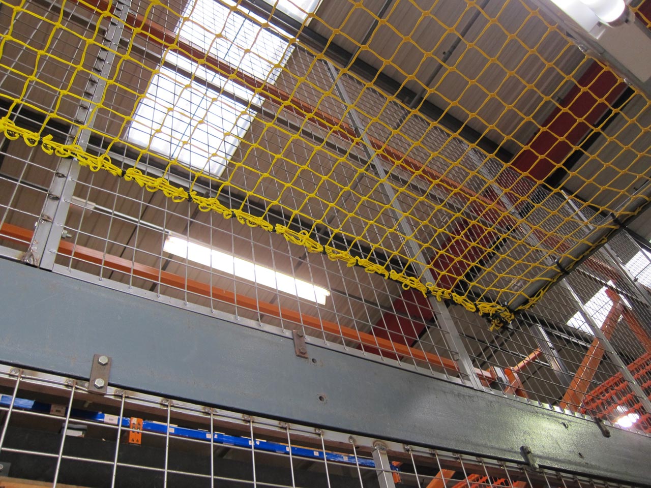 Overhead yellow knotted netting in a warehouse.